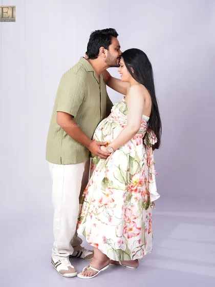 A simple, loving gesture. This studio portrait captures the husband's affection with a gentle kiss on his wife's forehead.