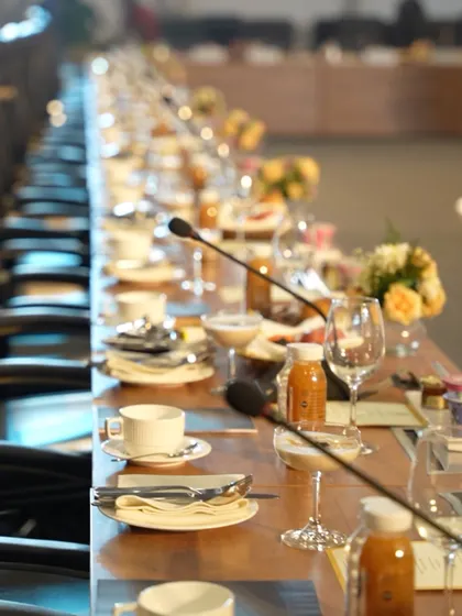 The setup for a boardroom-style meeting at a major conference. We provide catering for all formats, from large buffets to intimate, high-level meetings, with a focus on quality and discretion.