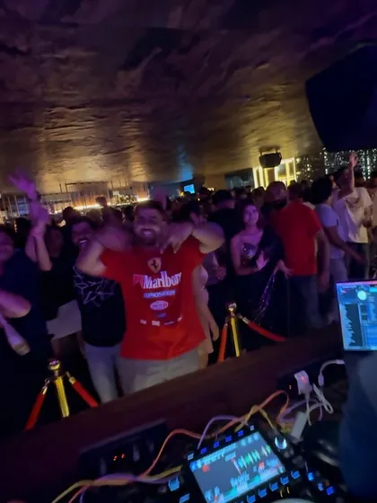 A guest with a huge smile, right in front of the DJ booth, feeding off the energy.