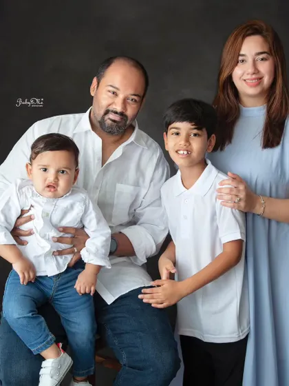 A lovely family of four posing for a classic portrait. The simple, coordinated outfits in white and blue create a timeless and elegant look.