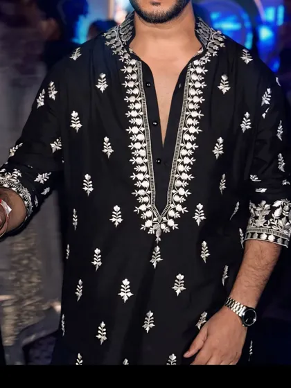 A close-up on the intricate white threadwork around the neckline of this black kurta. The detailed embroidery provides a sharp, stylish contrast against the dark fabric.
