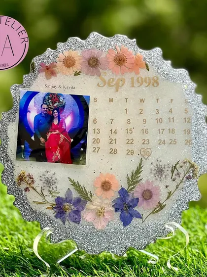 Celebrating 25 years of love with a silver jubilee calendar frame. This piece features a silver glitter border, a classic photo, and the September 1998 calendar, surrounded by delicate flowers.