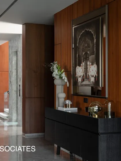 The entrance corridor combines rich woodwork with framed art and a sleek console, creating a gallery-like experience that welcomes you into the home.