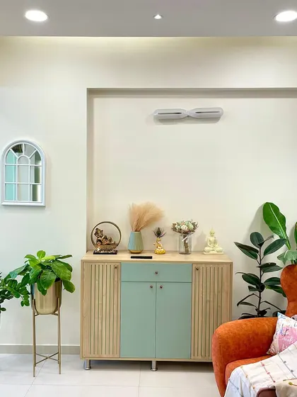 The custom mint green and wood console provides stylish storage. I believe in adding plenty of greenery, like these plants in gold stands, to bring life and freshness into a room.