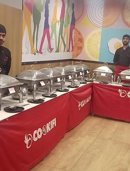 Our team ready to serve at a corporate event for Ninjacart. The colorful background complements our professional and vibrant food service.