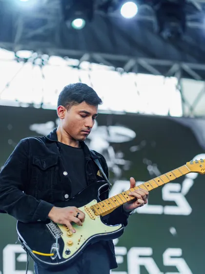 Our lead guitarist focused on a solo during a live concert. His riffs and solos are a key part of our Bollywood rock fusion sound.