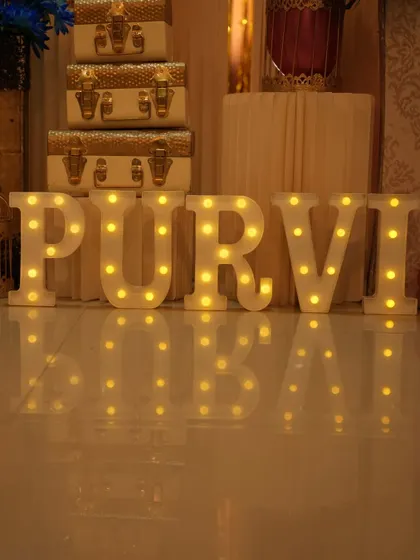Light-up letters spelling out the name 'PURVI' for a butterfly-themed party.