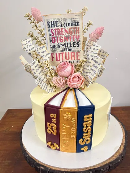 A book lover's dream cake for a 50th birthday. This design features a stack of 3D edible books and a beautiful topper made from actual book pages and dried flowers.