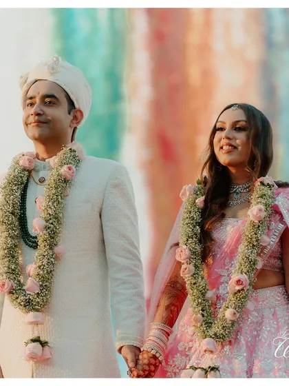 The couple, hand-in-hand, framed against a colorful backdrop, a beautiful portrait of their union.