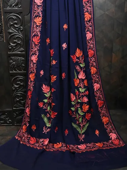 A navy blue georgette saree with vibrant floral embroidery along the border. The beautiful color combination makes it a striking choice for any festive occasion.