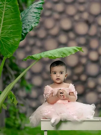 A beautiful princess in her pink dress, sitting under a giant leaf. Our garden is full of magical spots for enchanting photos.