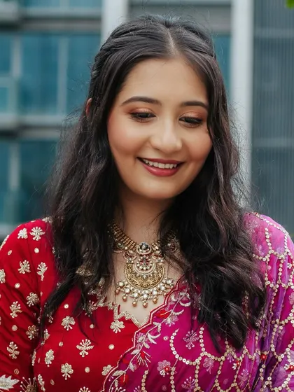 A close-up of the happy bride. Her smile says it all. The makeup is light and radiant, perfect for a daytime Roka ceremony.