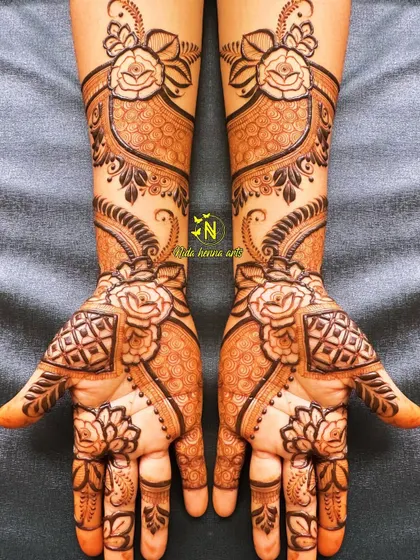 This design is all about floral work. It features large rose motifs on both the palms and the arms, connected by delicate patterns to create a cohesive and romantic look.