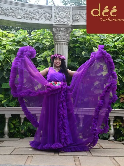The flowing sleeves of this purple ruffle gown add a dramatic flair, perfect for creating dynamic and beautiful maternity photos.
