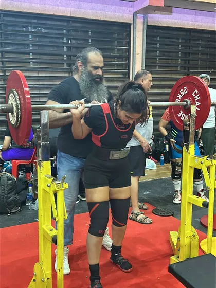 Getting ready for a heavy squat at a competition with my coach. This is what personalized, hands-on guidance looks like, ensuring you are safe and ready to perform.