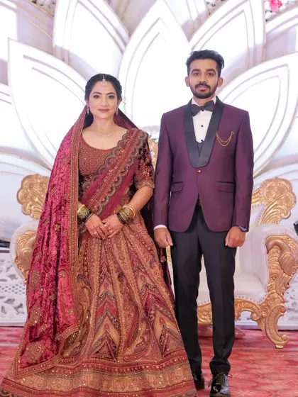 A full portrait of the couple. The bride's entire look, from makeup to her draped shawl, is perfectly styled.