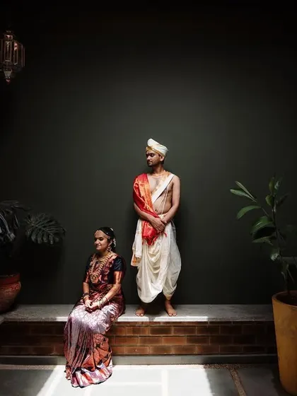 A striking portrait of a couple against a dark, minimalist background. This style emphasizes their traditional wedding attire and creates a powerful, artistic image.