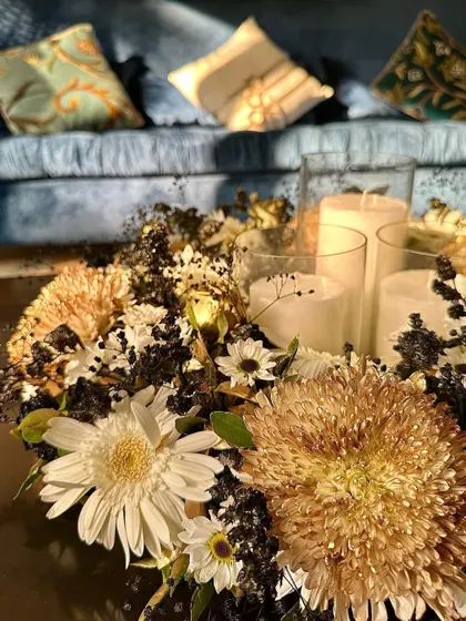 The golden hour light hitting this centerpiece is just beautiful. The mix of textures, from soft petals to dark, dried elements, creates a lot of visual interest.