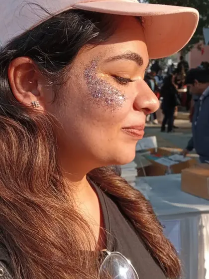 A close-up of a heavy glitter application on the cheekbone. The mix of fine and chunky glitter creates amazing texture and shine.