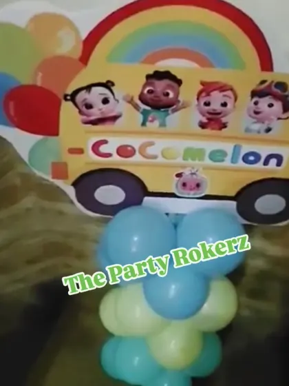 A Cocomelon-themed balloon pillar with a character cutout on top. These are great for decorating entrances or placing around the party venue.