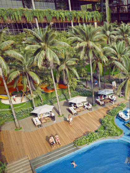 An aerial view of the pool and recreation area at the Westin Nashik. The design integrates the hotel seamlessly into its natural surroundings, with palm trees and green spaces creating a luxurious oasis.