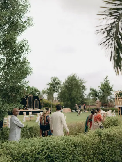 A wide shot of the outdoor wedding venue, showing the beautiful lawn and stage setup before the festivities begin.
