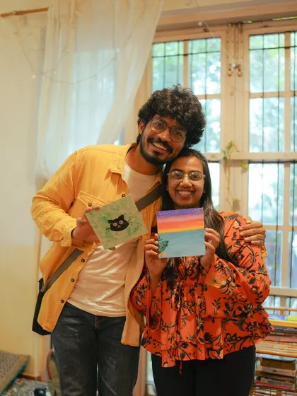 A happy couple shows off their creations from the "Paint with Kittens" event organized by Pawga. It's a purr-fectly creative way to support our rescued cats and kittens.