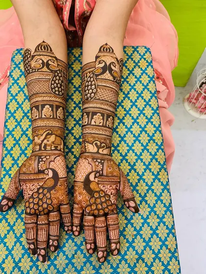 This design is a beautiful mix of traditional motifs. It features peacocks, elephants, and swans, all drawn with fine lines and detailed shading.