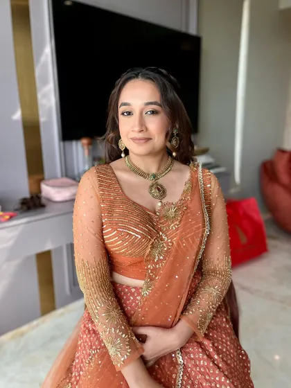 The final portrait of the client, looking stunning in her rust-colored lehenga and warm, glowing makeup.