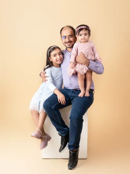 A father's pride, holding his two daughters close. A memory to be treasured for years to come.
