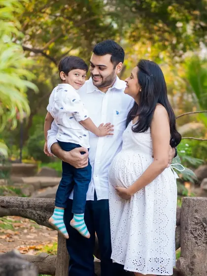 A classic family portrait pose during a maternity session. The older brother-to-be is held by his dad, creating a beautiful image of the family of three, soon to be four.