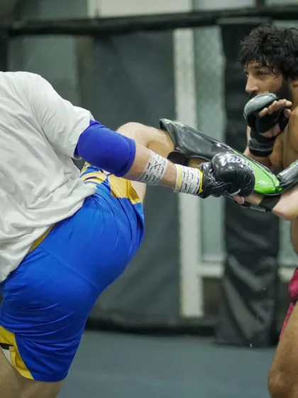 A fighter checks a kick during a heavy sparring session. We drill defensive techniques just as hard as offensive ones to create well-rounded martial artists.