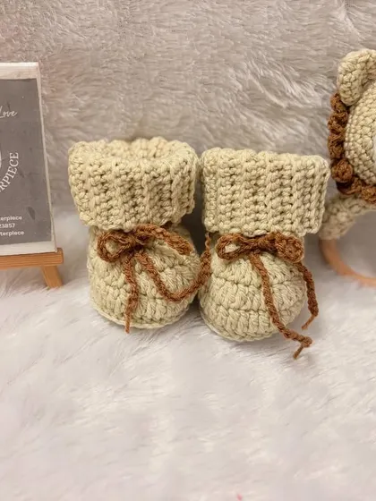 This unisex gift set features cozy, fold-over booties and a matching lion rattle with a wooden teether ring, perfect for snuggles and playtime.