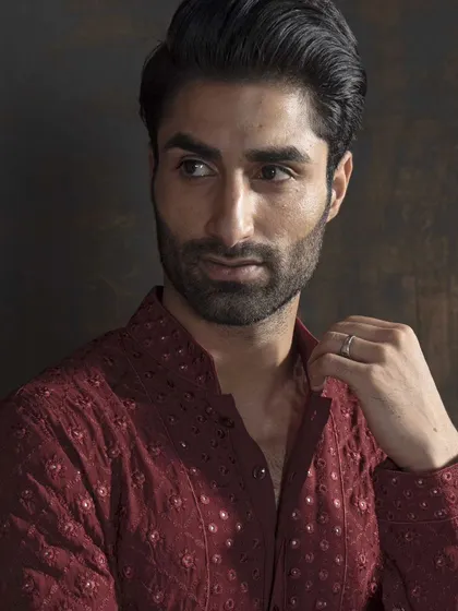 A close-up of a rich maroon kurta with delicate, all-over embroidery. This piece redefines elegance in traditional wear, celebrating both culture and style.