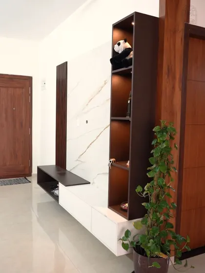 A modern TV unit with a white marble back panel and a dark wood display tower. The integrated lighting highlights the decor and adds a sophisticated touch.
