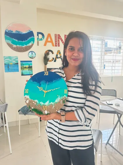 A repeat image of a participant with her completed beach resin clock.
