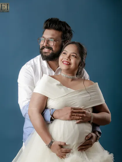 Looking towards the future together. This couple's portrait captures their shared dreams and happiness against a solid blue studio backdrop.