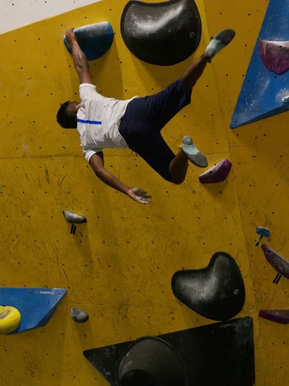 A climber airborne, captured at the peak of their jump during a Dyno session. These photos show the athleticism and explosive strength we focus on in our workshops.