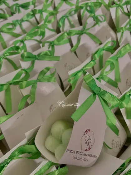 A large batch of our baby bubble candles in custom cone packaging with green ribbons, prepared for a wedding celebration.