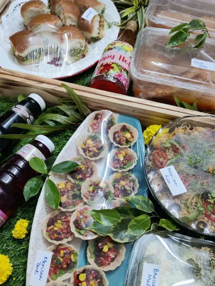 A festive Holi hamper filled with a colourful assortment of our homemade vegetarian dishes, including Mexican tarts, pasta salad, and refreshing drinks.