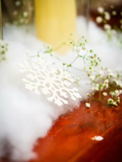 A close-up of a snowflake ornament resting on a cloud of cotton snow, a simple yet effective detail that evokes the feeling of a winter wonderland.