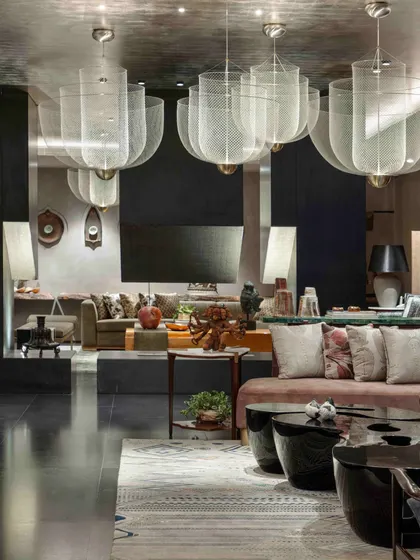 The formal living room in the basement, a harmonious blend of history and modernity. The space is defined by large mesh pendant lights, custom furniture by Furgonomics, and a curated collection of art from around the world.