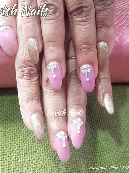A royal combination of matte pink and shimmering gold nails, with the pink nails adorned with an intricate, teardrop-shaped crystal design.