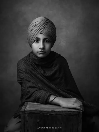 A classic black and white portrait, capturing the quiet confidence and grace of this young boy. The lighting and composition are reminiscent of old master paintings.