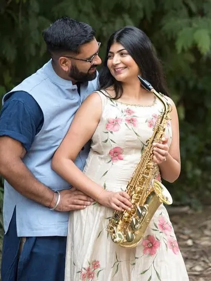 A romantic outdoor portrait of a couple. Using a prop like a saxophone can add an element of elegance and shared passion to the photos.
