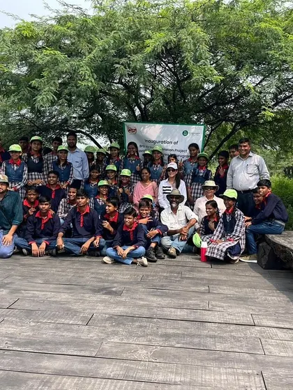 A group of students and volunteers from Bry-Air pose on the wooden deck at Aravali Nagar Van, a viewpoint overlooking the restored landscape.