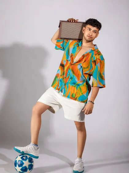 A vibrant, tropical-themed shoot for a men's summer collection. I paired a colorful printed shirt with white shorts and casual accessories like headphones and a speaker to create a fun, youthful, and energetic vibe.