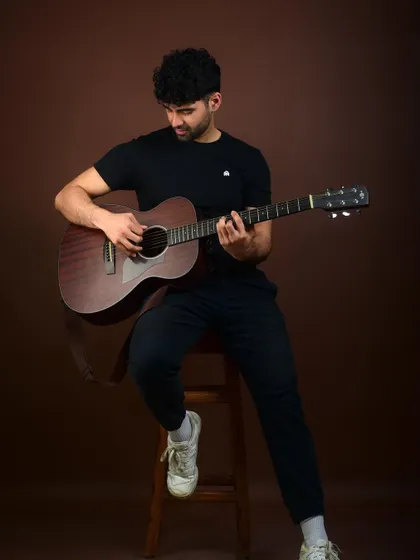 An actor's portrait with a guitar. This not only shows a skill but also creates a mood, suggesting a creative, soulful, or musical character type.
