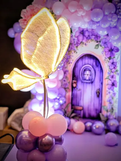 A close-up of a light-up butterfly prop, adding a warm glow to the enchanted theme.