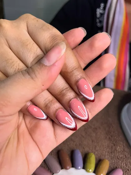 A close-up of this modern red and white double French design, showing the clean lines and almond shape before the final top coat.